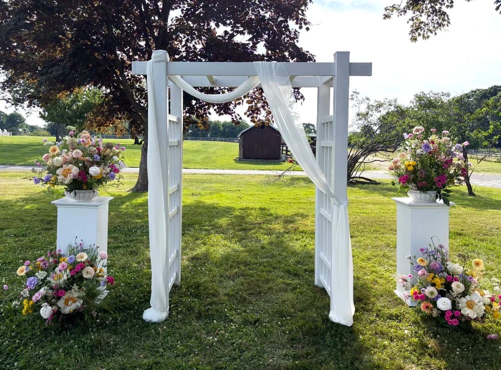 Traditional white wedding arch at a ceremony