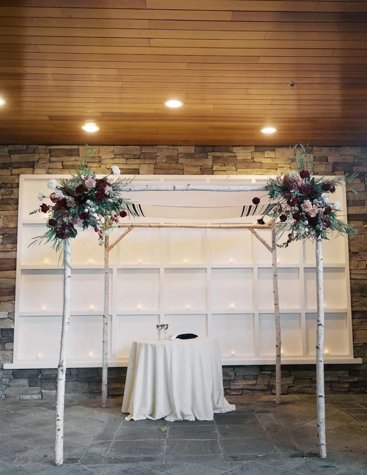 White birch wedding canopy on a wooden dock